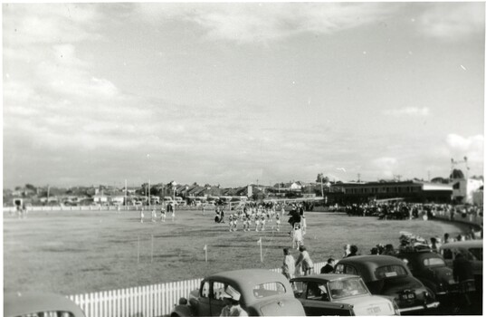 Image of a sports field, with many people both on and around it. 