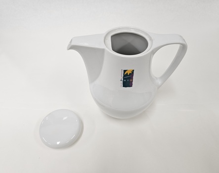 Small white coffee pot with purple, green and yellow Moorabbin Arts Centre Logo with lid removed and placed to left