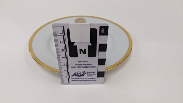 White bread and butter plate with gold edging and City of Moorabbin logo with scale to 8cm placed against centre