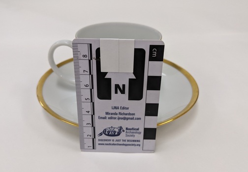 White cup and saucer with gold edging and City of Moorabbin logo with scale to 8cm placed against centre
