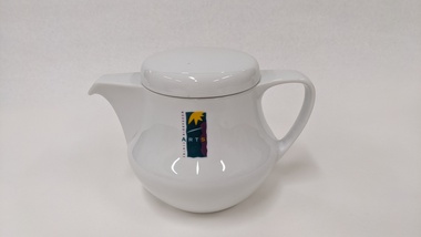 Small white teapot with purple, green and yellow Moorabbin Arts Centre Logo