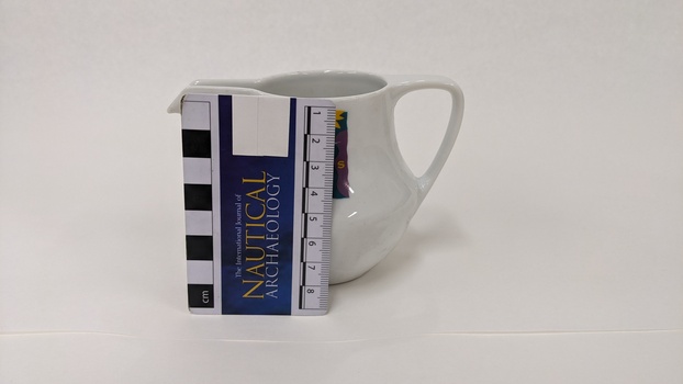 Small white milk jug with purple, green and yellow Moorabbin Arts Centre Logo with small scale to 8cm placed against left side