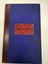 Front cover of minute book, heavy blue card with red leather spine.