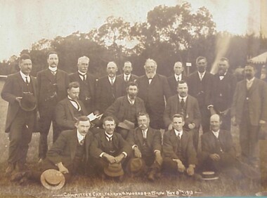 Three rows of men dressed in suits grouped together for a photograph