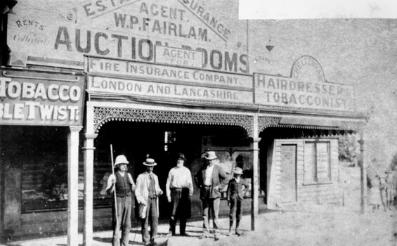 A group of four men and a boy are standing out the front of William Fairlam's store