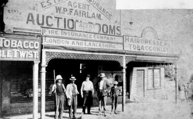 A group of four men and a boy are standing out the front of William Fairlam's store