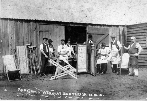 A group of eight men standing in front of a shed