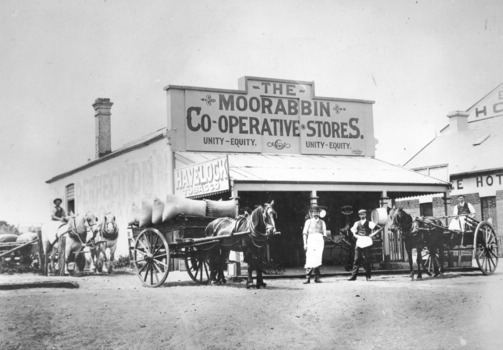 Two men standing in front of Moorabbin Co-operative Store with two horse drawn wagons