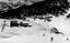 Photo of the lodge buildings from above, A small number of skiers are on the slopes,