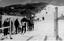 People lined up at the tow with others visible further up the slope