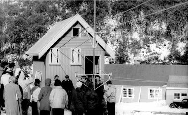 Opening the Village Tow 1959. A group of people gathered around and buildings in the background.