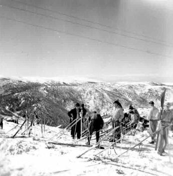 Group of skiers on the summit. Panoramic views in background.
