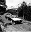 Truck and trailer ascending unsealed mountain road.