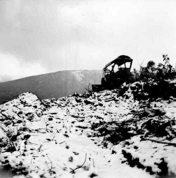 Small bulldozer on top of mountain slope