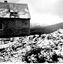 Building with corrugated iron roof on left. Thinly snow covered mountain in background