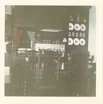 Inside the kitchen with large traditional dresser filled with china plates. Table in foreground