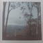 Mountain framed by trees and fence in the foreground. Location unknown