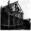 Men standing on top of lodge securing the roof framework in place.