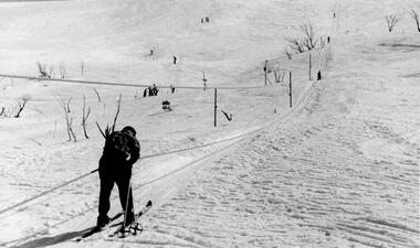 Single skier at the foot of the tow, with others visible higher up.