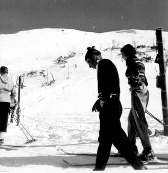 Fred Griffith and friend walking at base of slope. Tow line in background