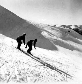 Two unknown skiers descending the slope
