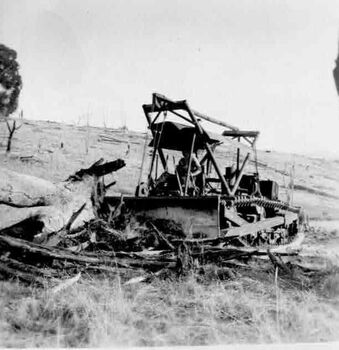 Old machinery, possibly a snow plough on a gentle slope. Man operating controls