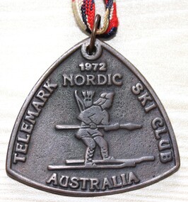 Triangular medal with image of a Nordic Skier and text