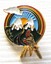 A badge featuring 2 mountains with the sun between them. 2 birds are perched on the lower edge.