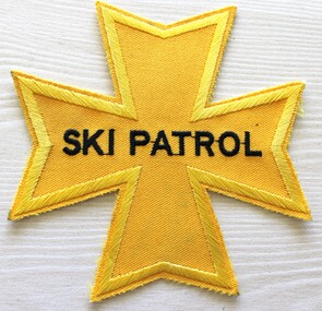 A yellow cloth star-shaped badge embroidered in black,