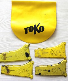 A yellow soft plastic pouch and four scrapers