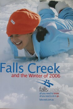 Image of a smiling woman sliding face down on the snow.