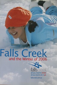 Image of a smiling woman sliding face down on the snow.