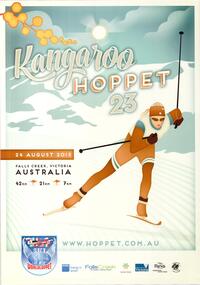 A skier dressed with mountains and sky in the background. A sprig of wattle is in the upper left corner. 