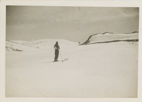 Joan Meyer on the slope with clouds overhead.