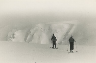 Two skiers at Eskdale Saddle with West Peak in the background