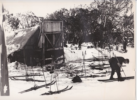 Skier, skis and poles outside Wallace's Hut.