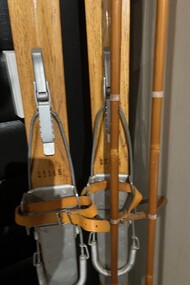 A set of wooden skis with bindings and poles
