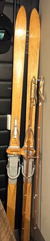 A set of wooden skis with bindings and poles