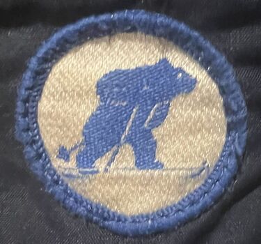 Cloth brand badge of blue bear on skis
