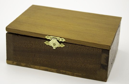 Honey coloured rectangular wooden box with hinged lid, secures at front with gold clasp