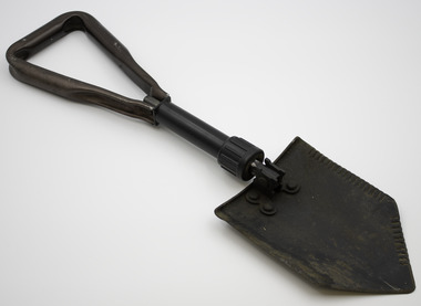 Folding spade  with a short shaft and triangular handle that unfolds from the blade and is locked when opened  with a screw.