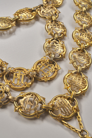 Close up of gold mayoral chain links.