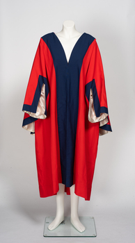 Red loose fitting ceremonial robe with contrasting broad band of blue fabric on lapel and collar. Square cut sleeves lined with cream fabric. 