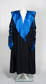 Full length black robe with large blue lapels. Sleeve detail includes buttons and matching blue ribbon.