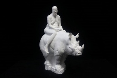 A human figure sitting on top of a white Rhinoceros
