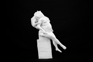 A human figure with a lion on the back biting the human's neck