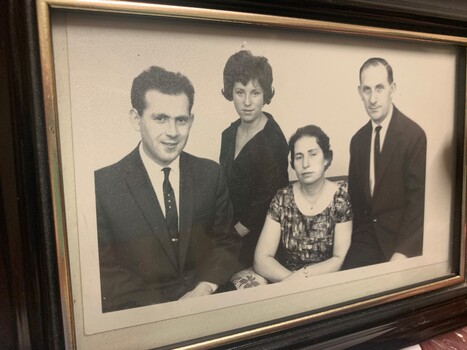 Black and white photograph of a family, pictured in a frame