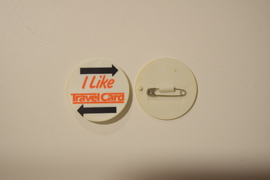 A white round badge with "I Like TravelCard" printed in front, presumably for advertisement purposes.