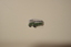 A metallic badge in the likeness of an AEC Regal Mk3 bus, presumably for commemorative purposes.