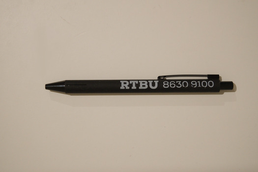 Black retractable pen with white text printed on the side advertising the RTBU.
